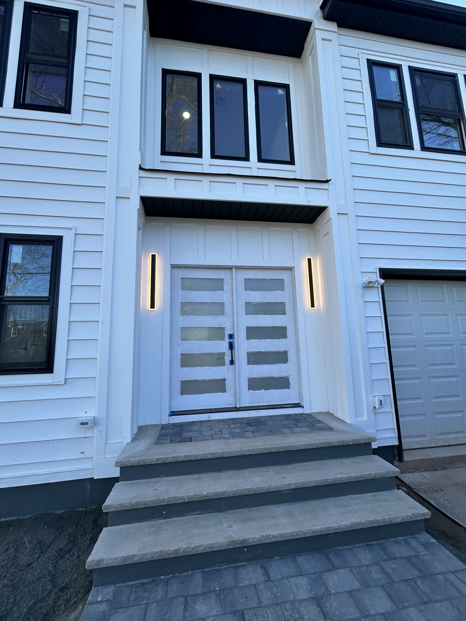 Modern black-and-white double-door entrance of a Rise Builders new-construction home